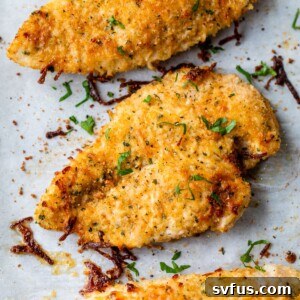 baked parmesan chicken breasts on a baking sheet