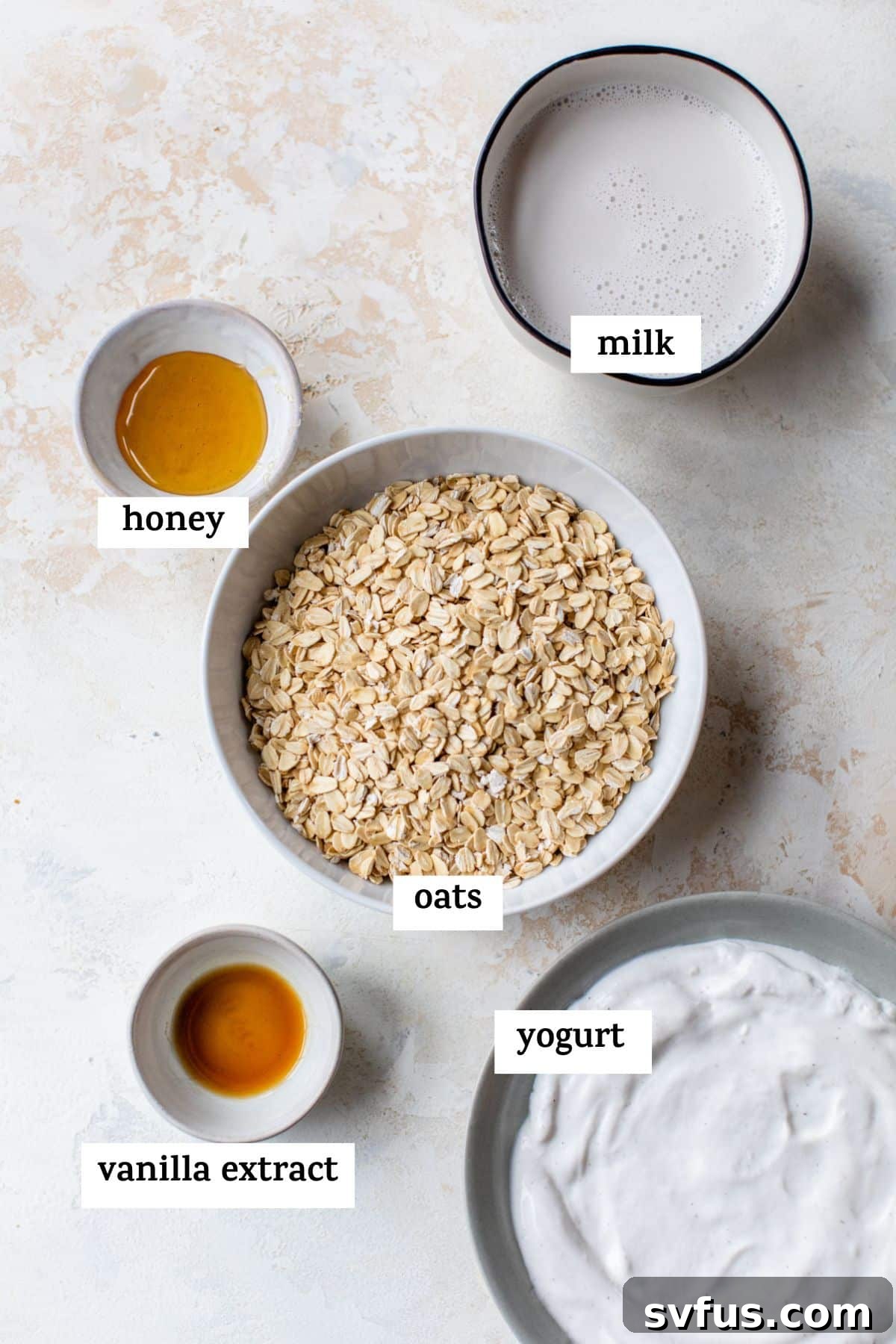 an overview shot of the ingredients for the overnight oats; milk, honey, oats, vanilla extract, and yogurt