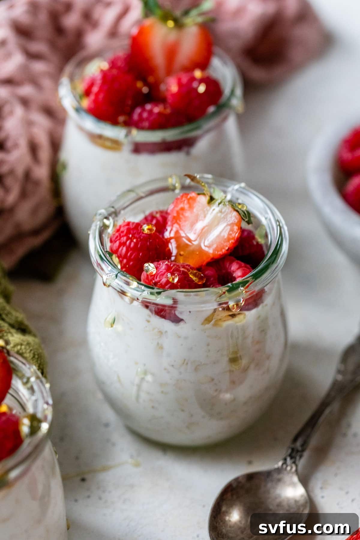 overnight oats in a mason jar with raspberries and strawberries on top