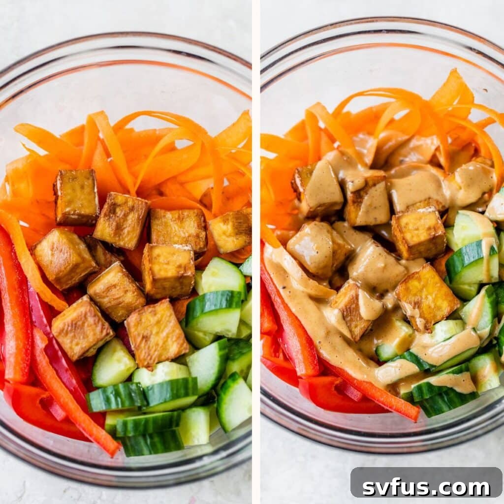 A clear glass bowl filled with colorful sliced carrots, red bell pepper, cucumber, and golden-brown fried tofu cubes.