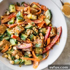 A bowl of fried tofu with veggies and a peanut sauce