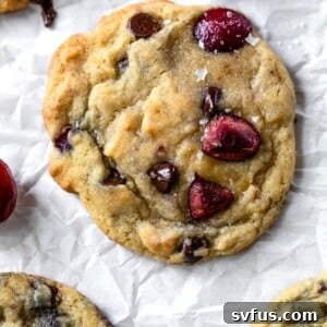 chocolate chip cookie with fresh cherries on a piece of parchment paper