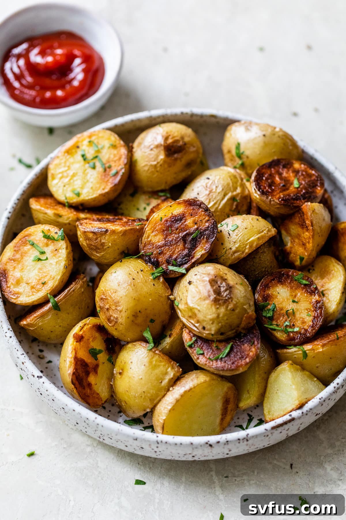 Overview of grilled potatoes on a plate with a side of ketchup