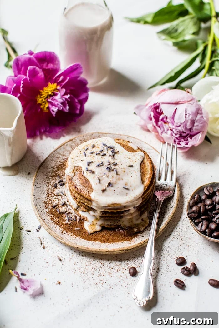 Fluffy Lavender Espresso Pancakes topped with lavender glaze and maple syrup, a perfect gourmet breakfast idea.