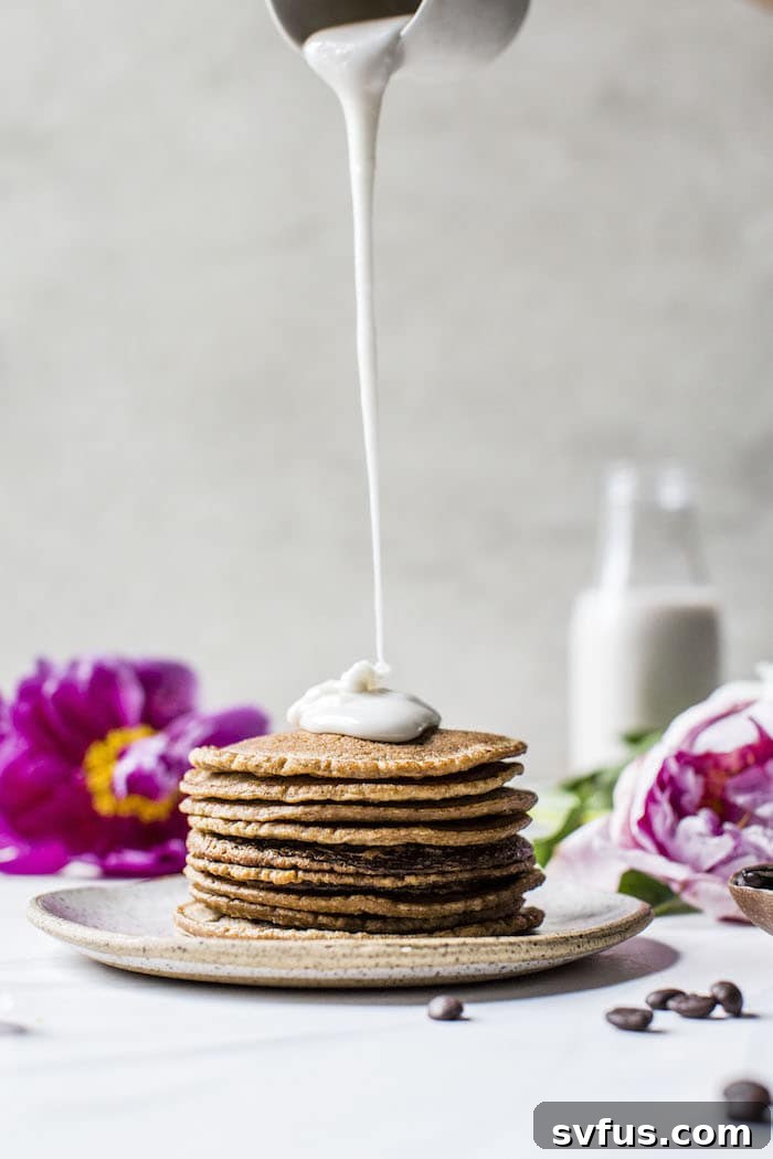 Close-up of a stack of golden brown Lavender Espresso Pancakes, glistening with lavender glaze.