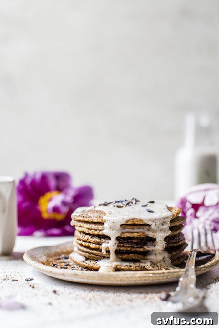 A close-up shot of the perfectly golden Lavender Espresso Pancakes, highlighting the sweet, glossy lavender glaze.
