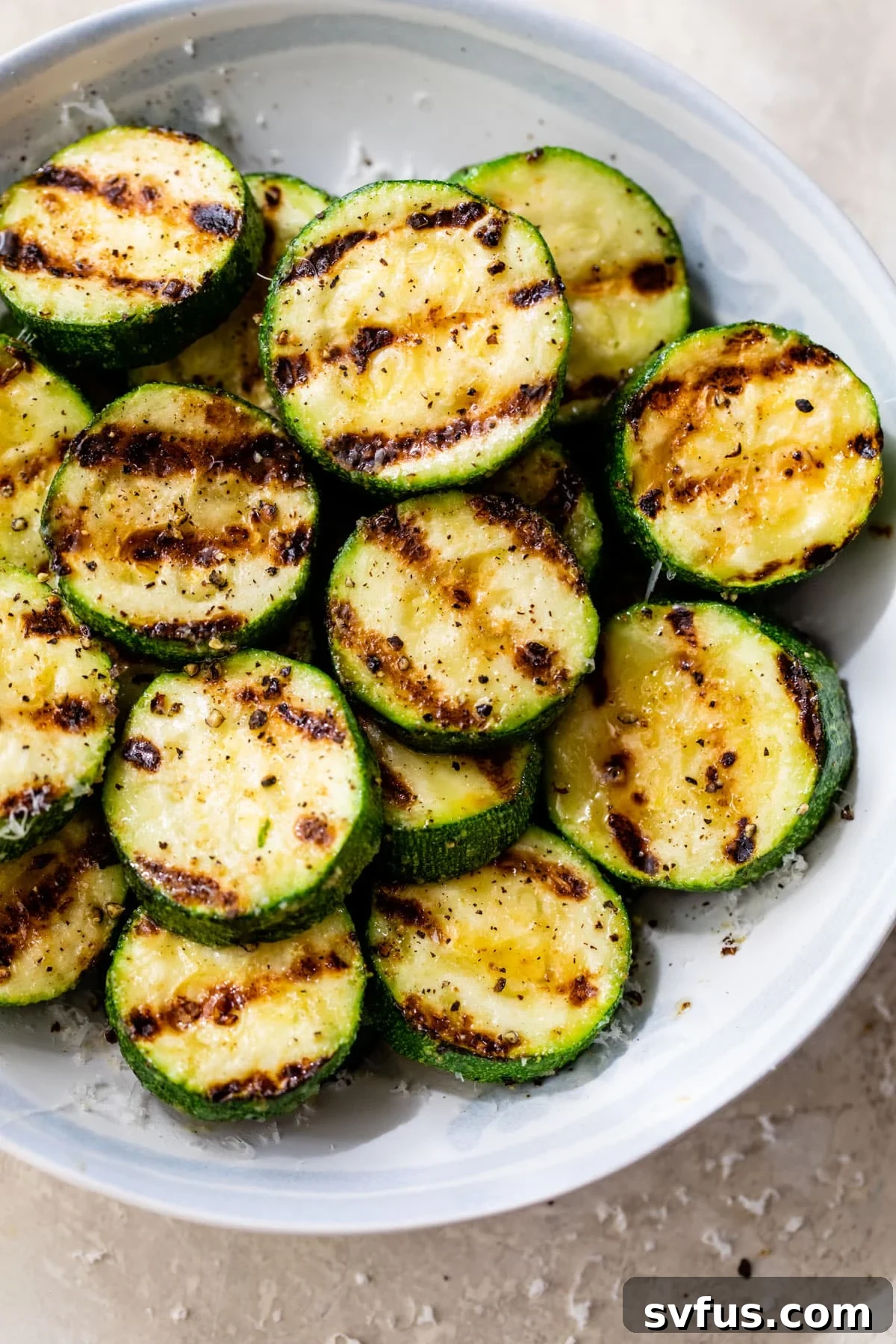 Grilled zucchini slices perfectly seasoned in a bowl, ready to be served