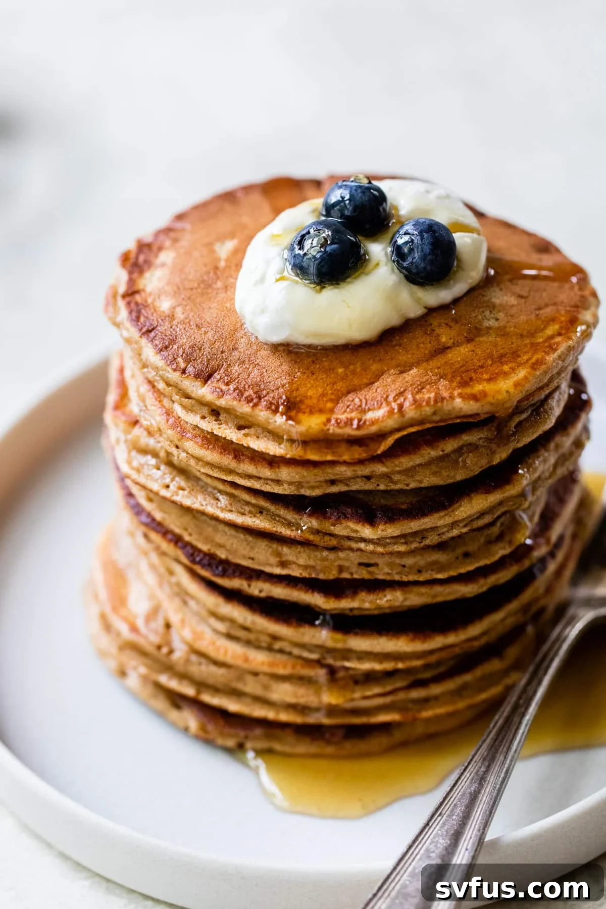 a stack of pancakes with yogurt and blueberries on top