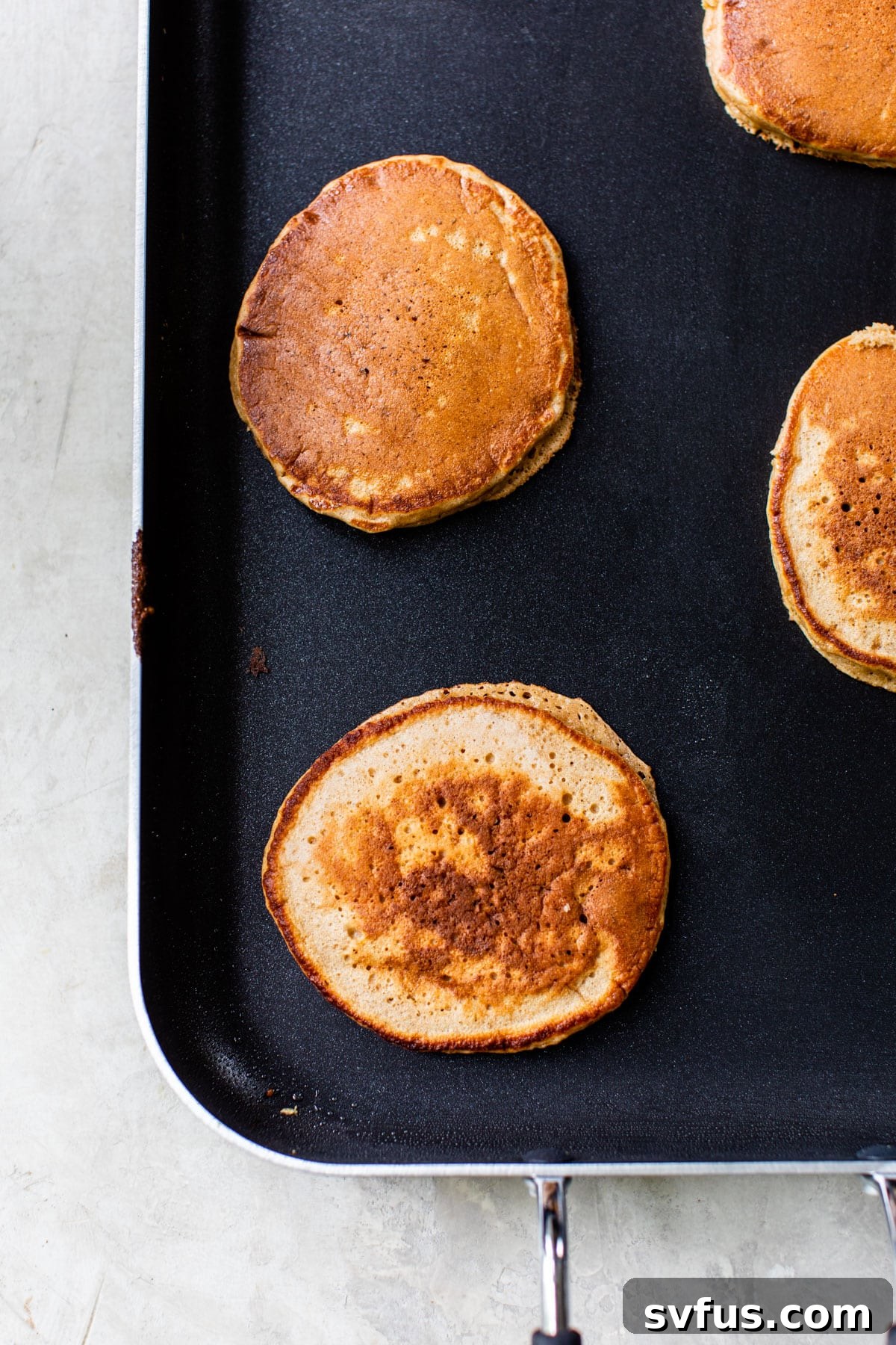 pancakes cooking on a griddle