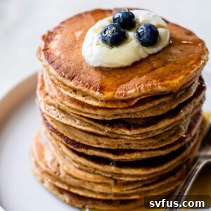 a stack of pancakes with yogurt and blueberries on top