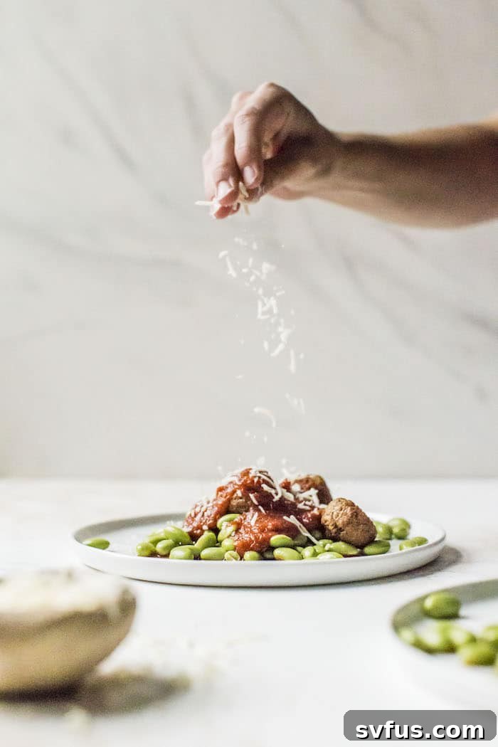 A serving of 10-minute meatless meatballs with edamame and marinara, topped with shredded cheese.