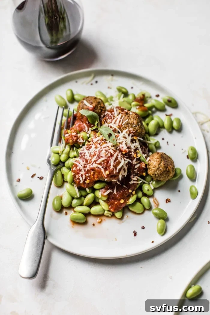 Close-up shot of the finished dish, highlighting the texture of the meatless meatballs and the freshness of the edamame.