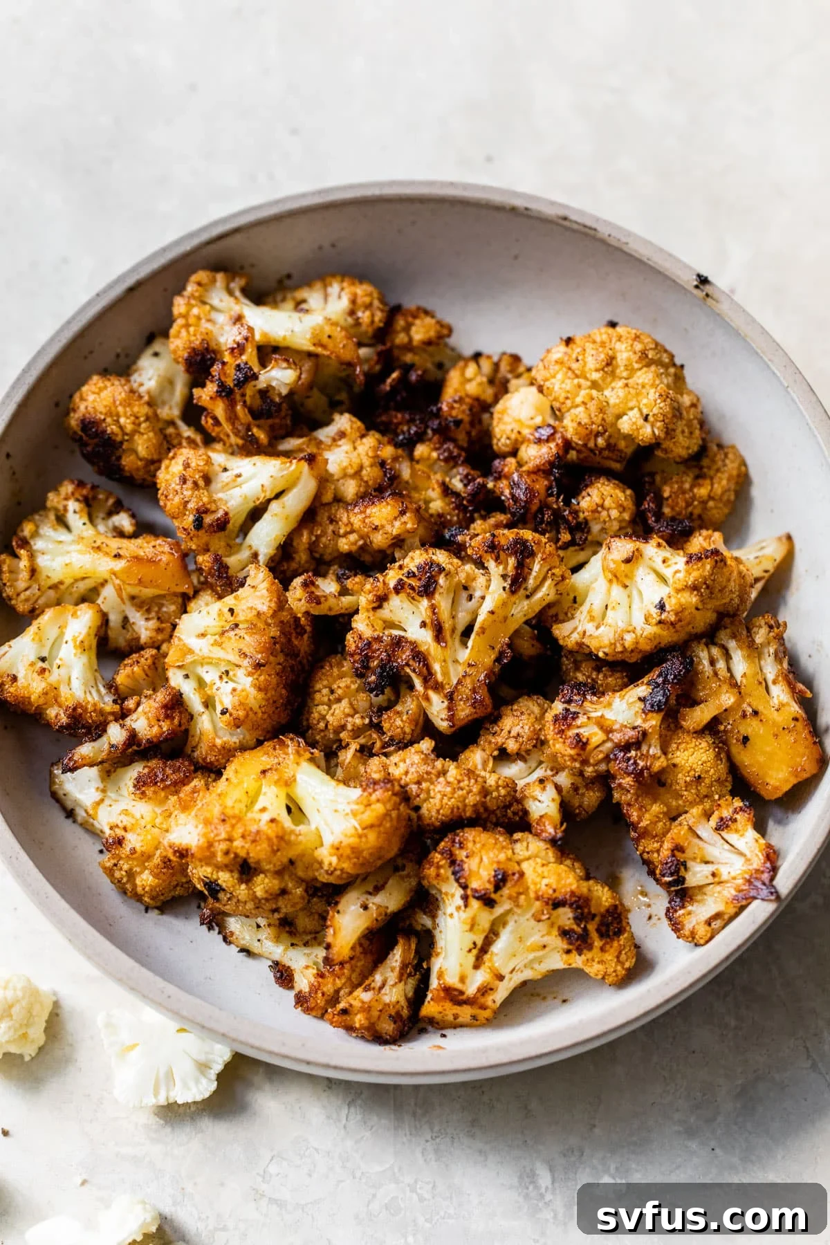 Perfectly grilled cauliflower florets on a serving plate, lightly charred and seasoned