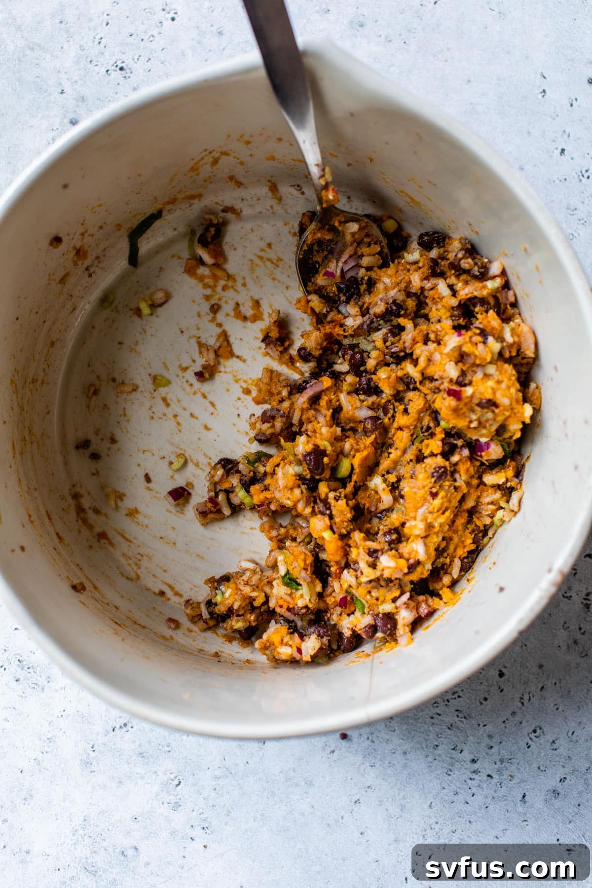 burger mixture in a bowl with a spoon, showing the combined ingredients.