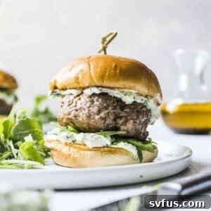 Grilled lamb burger on a plate with pesto whipped feta
