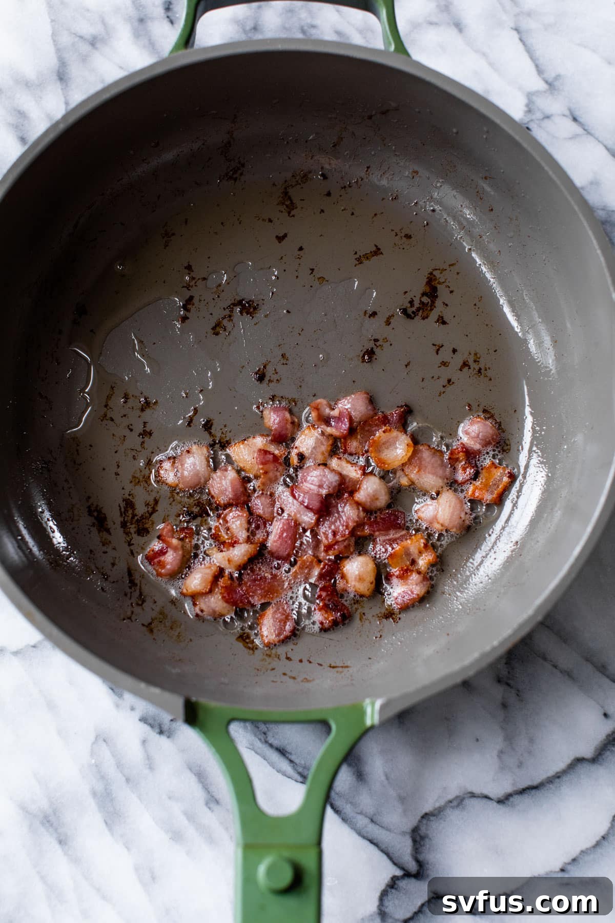 bacon pieces cooking in a skillet