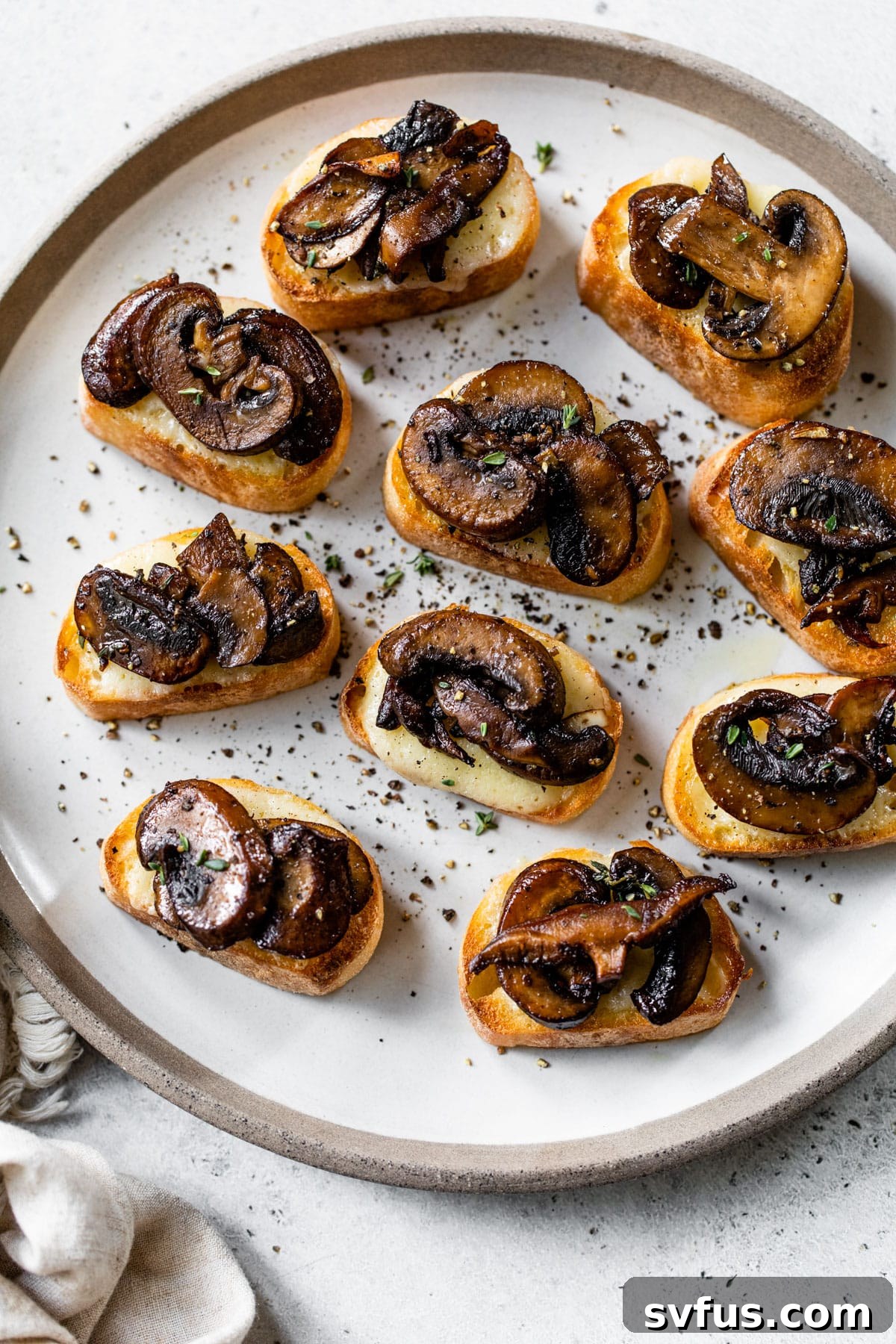 A stunning plate of mushroom bruschetta, garnished with fresh herbs and a balsamic drizzle, ready to be served at a gathering.