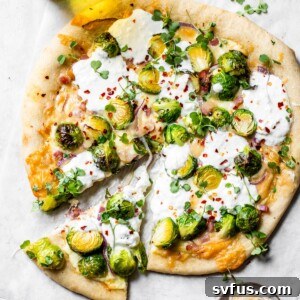 pizza on parchment paper beside a glass of beer