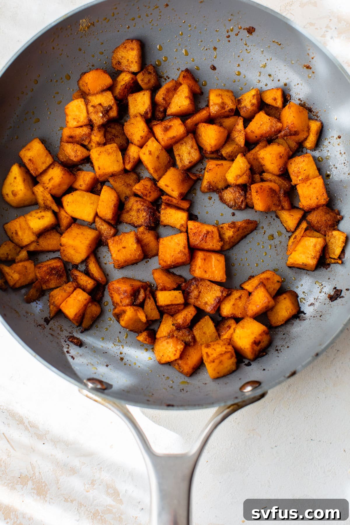 cubed butternut squash cooking in a skillet