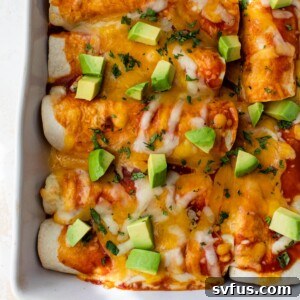 butternut squash enchiladas in a baking dish topped with diced avocado