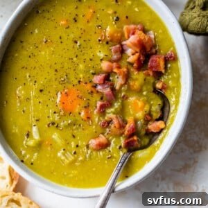 A beautifully presented bowl of creamy Instant Pot Split Pea Soup, topped with crispy pancetta pieces.