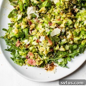 A vibrant Brussels sprouts salad with bacon and arugula on a white plate