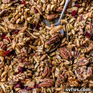 granola on a baking sheet with a spoon