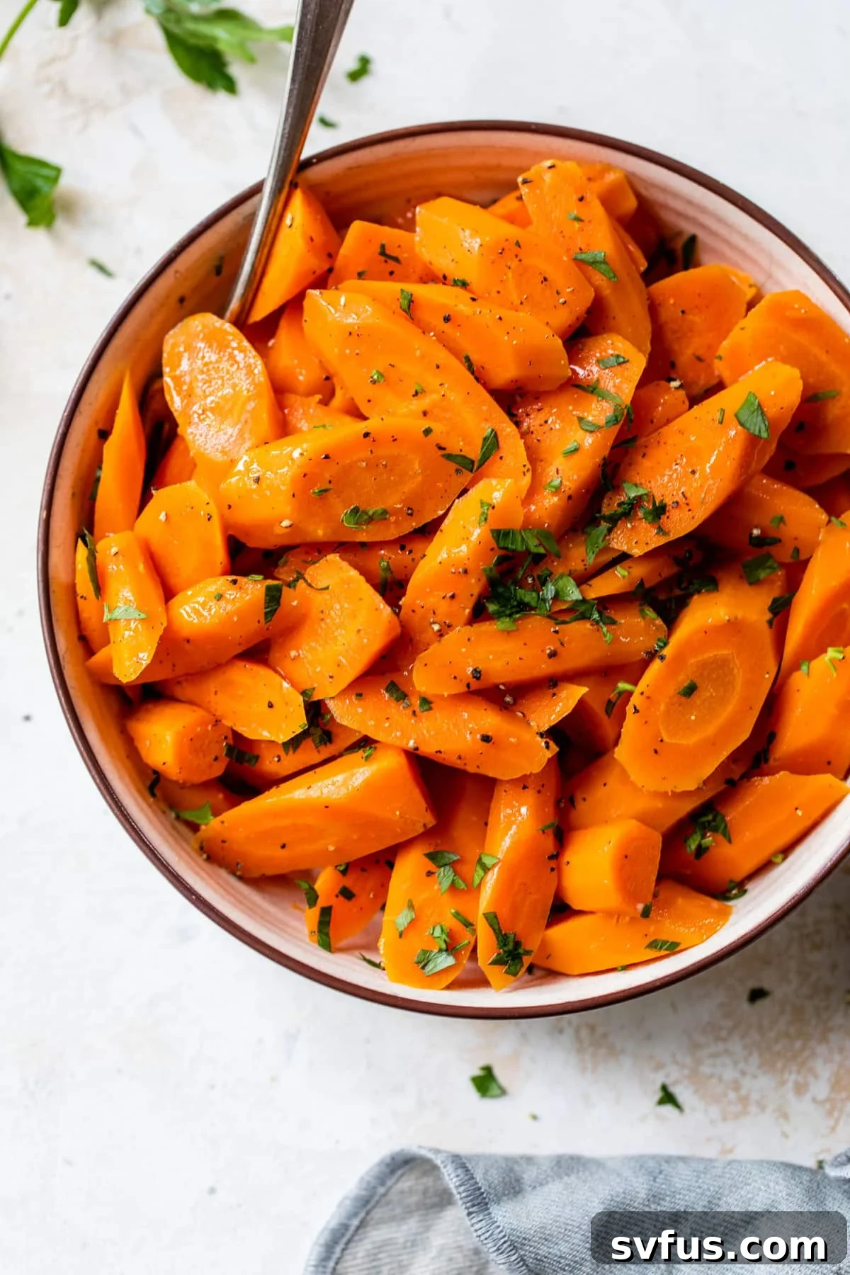 instant pot carrots inside a bowl with a fork and fresh parsley on top