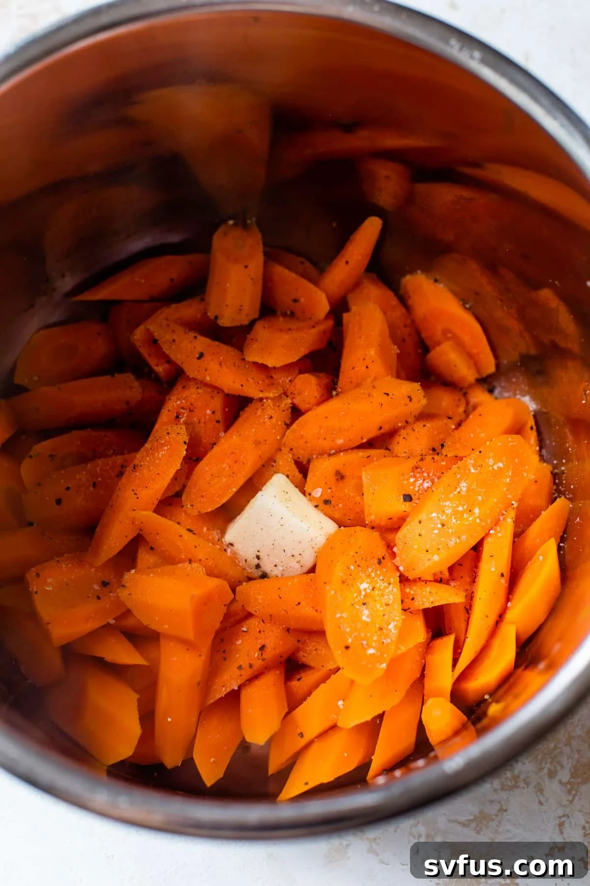 sliced carrots inside an instant pot with salt, pepper, and butter