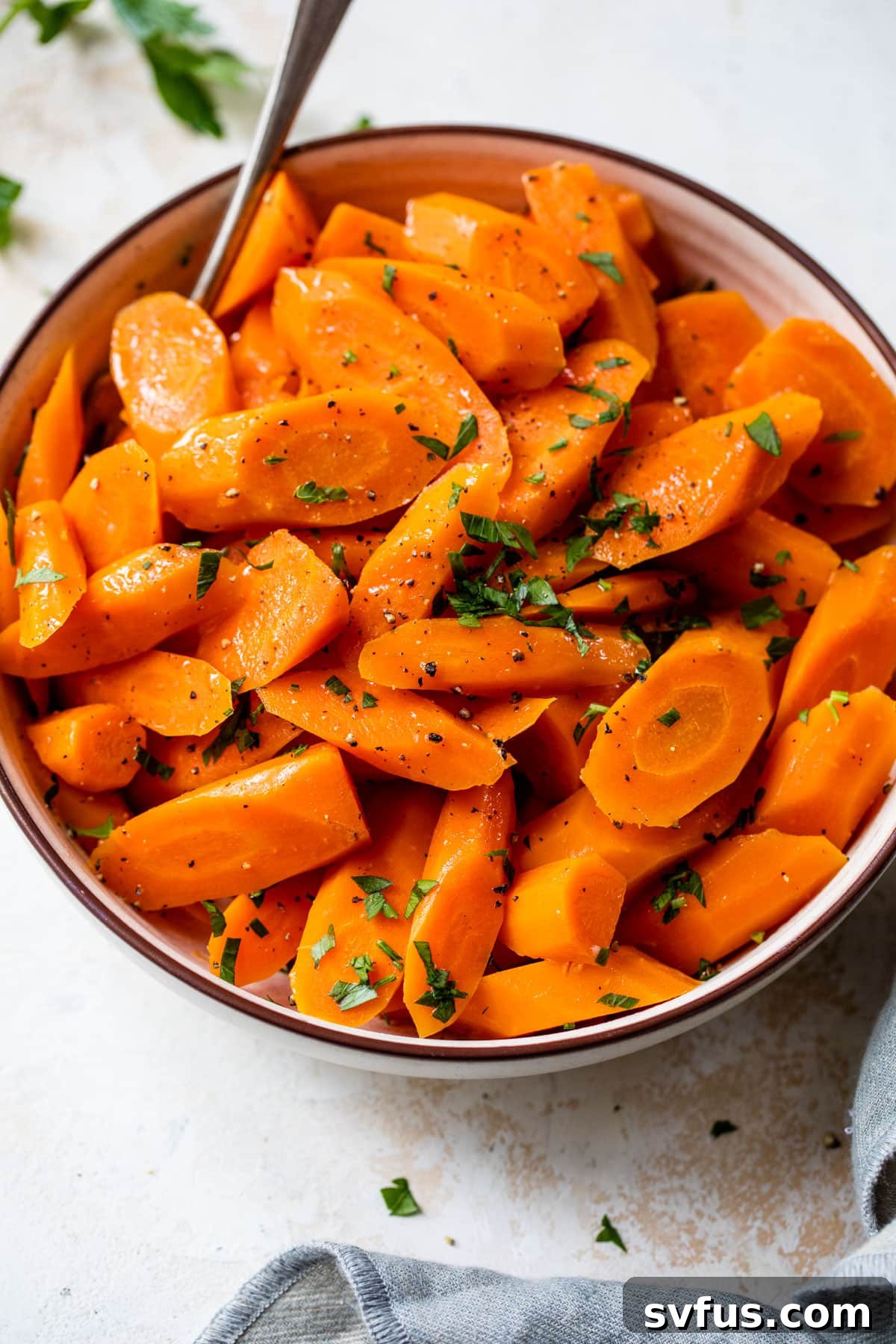instant pot carrots inside a bowl with a fork and fresh parsley on top