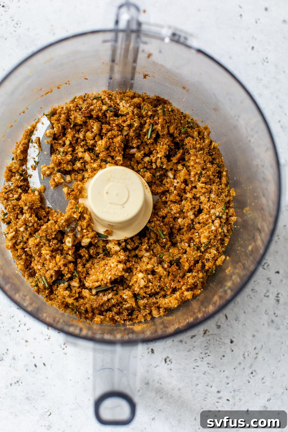 All filling ingredients, including toasted nuts, breadcrumbs, herbs, and spices, blended in a food processor to form a fine, fragrant mixture.