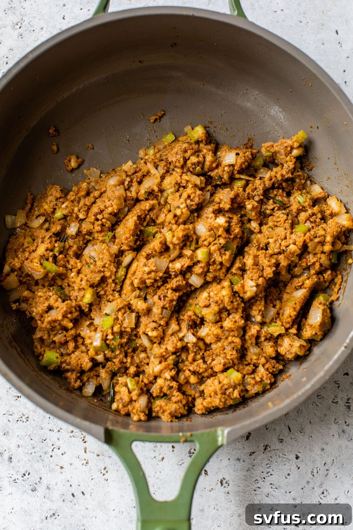 Filling ingredients, including sautéed onion, celery, and the ground nut mixture, cooking in a pan with red wine, infusing deep flavors.