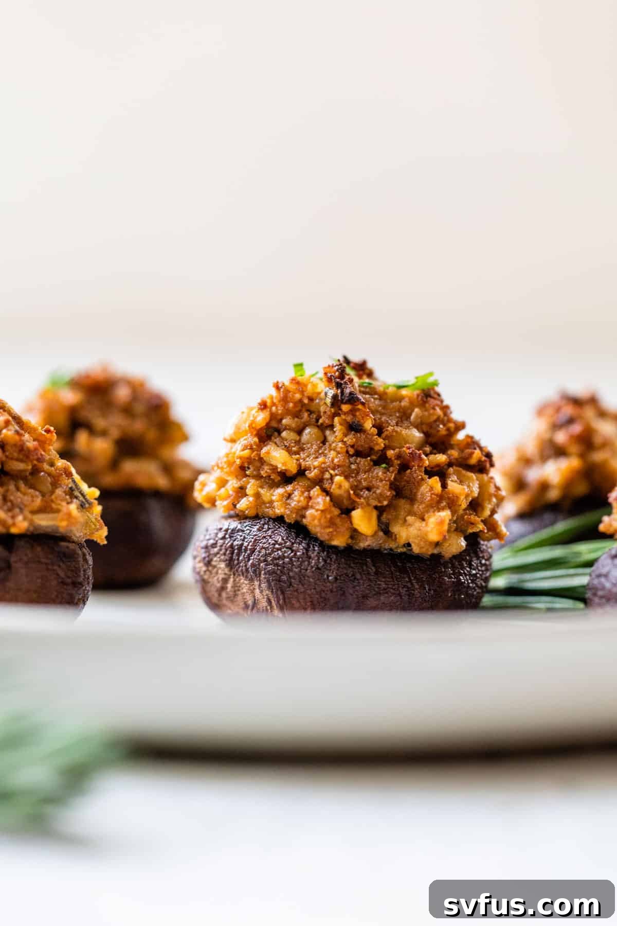 Close-up side view of a perfectly baked vegan stuffed mushroom, showing its rich, textured filling.