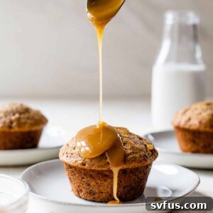 a vegan sticky toffee pudding on a plate with caramel drizzled over the top with a spoon