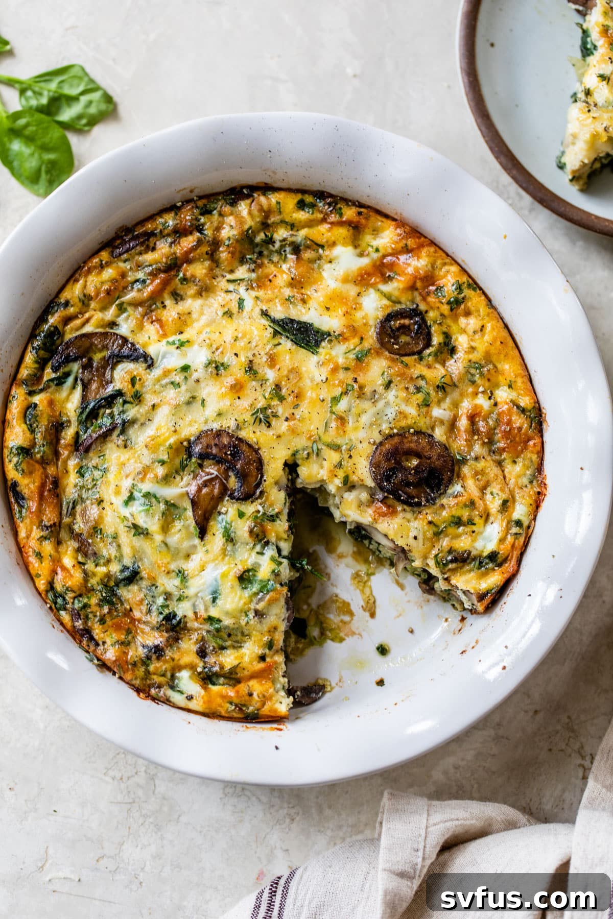 overview of the spinach mushroom quiche with a slice taken out