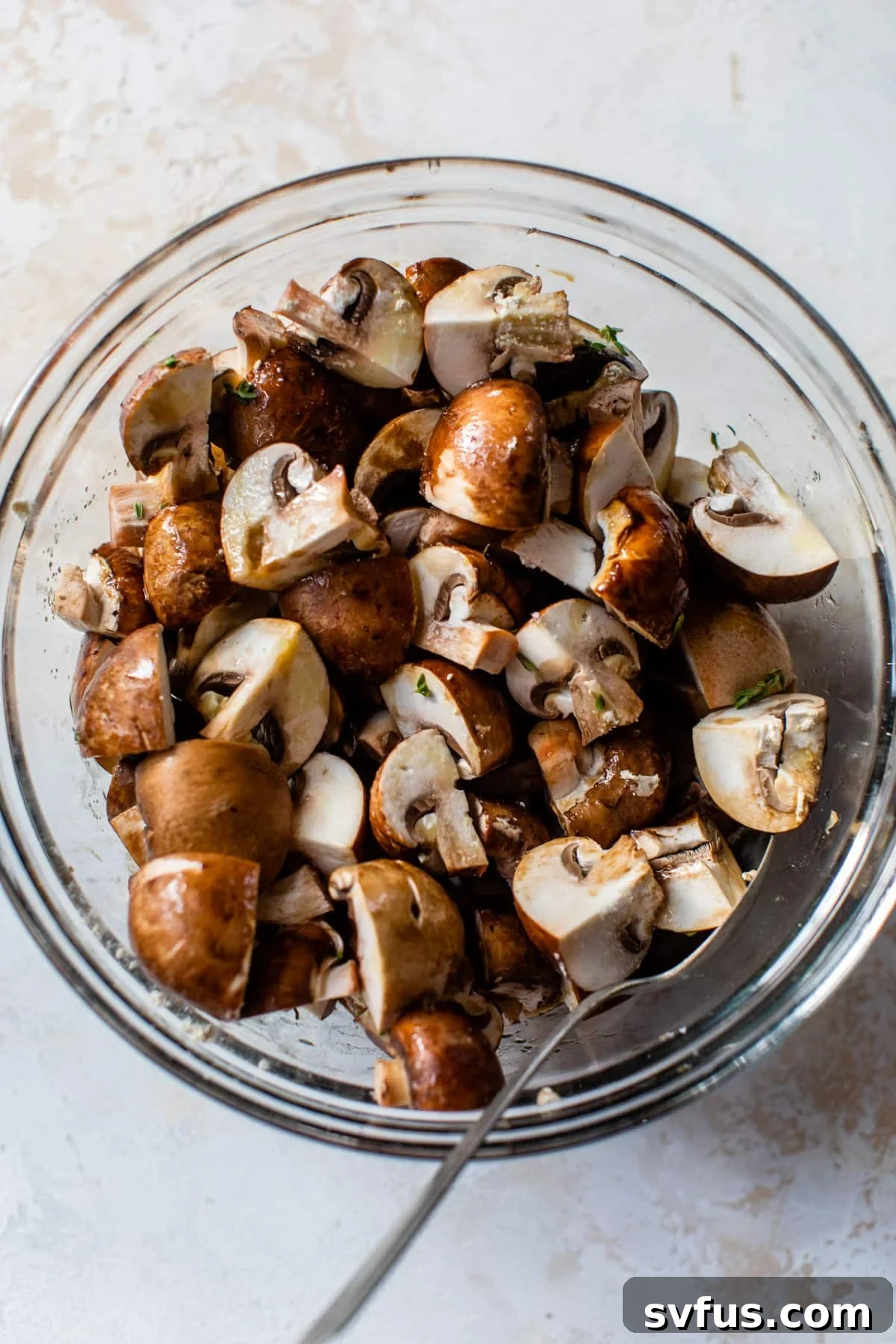 chopped mushrooms in a glass bowl with a spoon