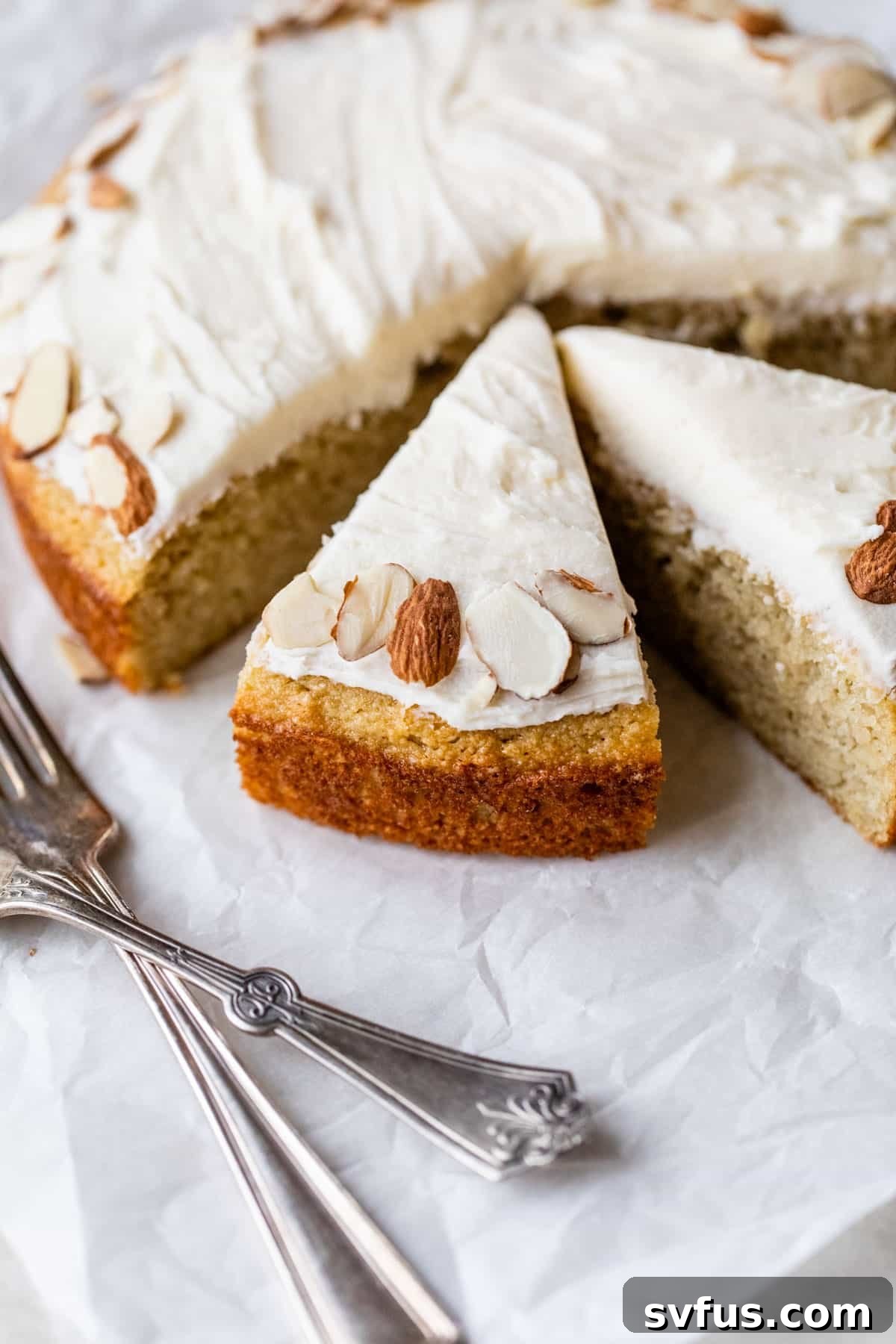 side view of almond flour vanilla cake sliced with almonds on top