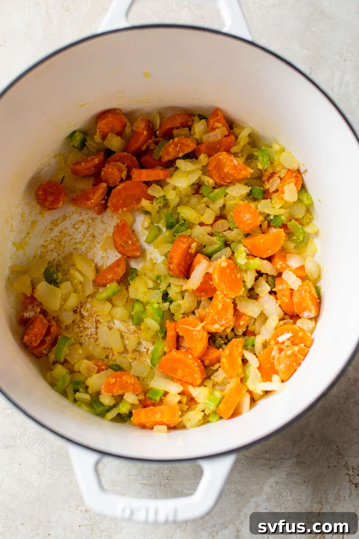 onion, carrots, and celery sauteing in flour in a dutch oven