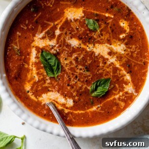 Creamy Tomato Basil Soup ready to serve, garnished with basil and a swirl of cream.