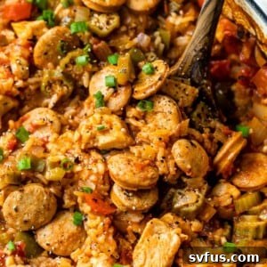 close-up of chicken and sausage jambalaya in a dutch oven with a wooden spoon