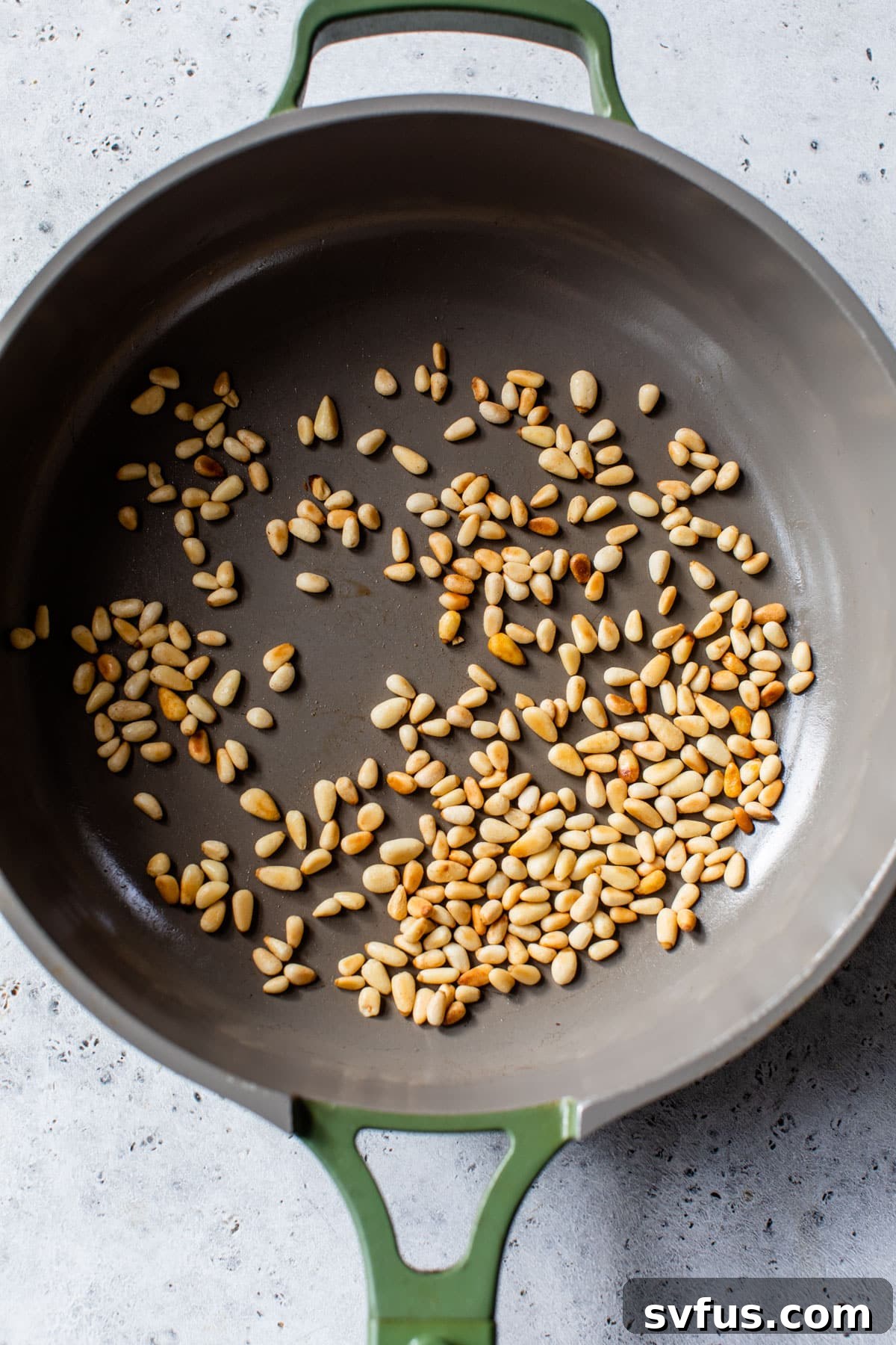 pine nuts toasting in a skillet