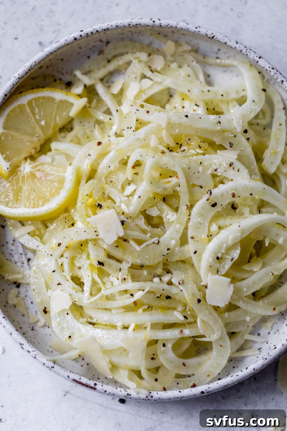 Finished fennel salad beautifully plated with lemon slices for garnish, ready to be served.