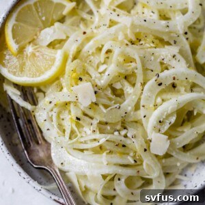 fennel salad on a plate with lemon slices and a fork