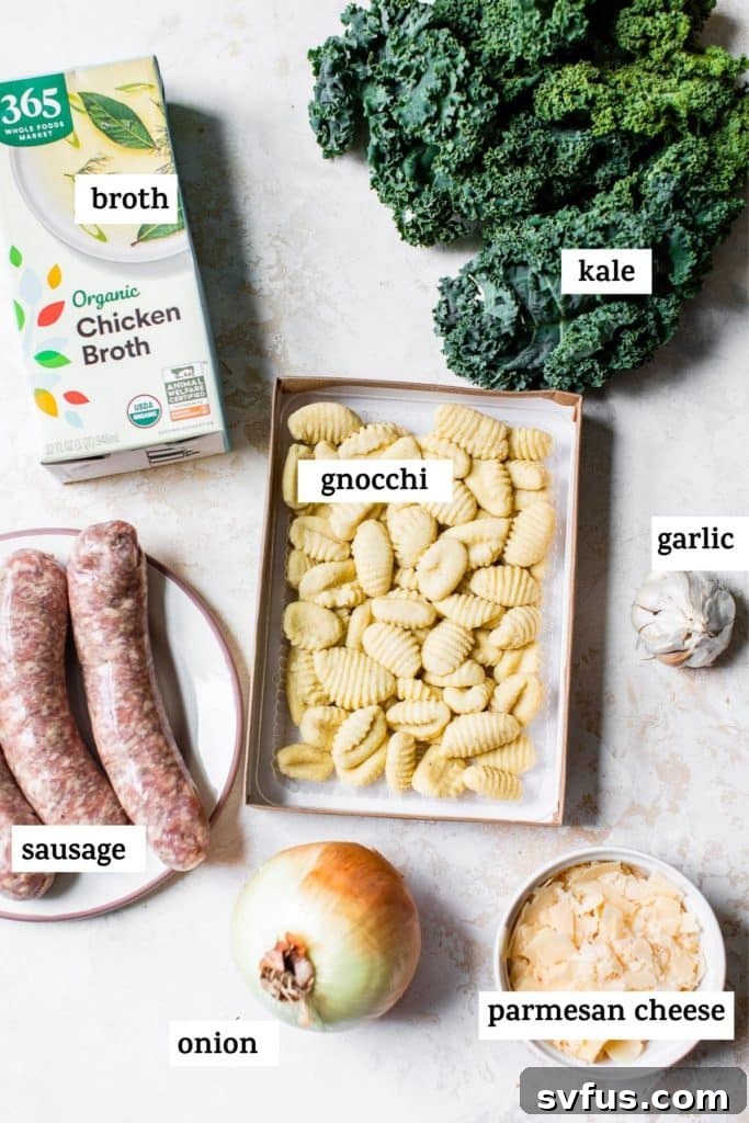 Various ingredients for gnocchi soup laid out on a wooden table, including kale, sausage, gnocchi, and onions.