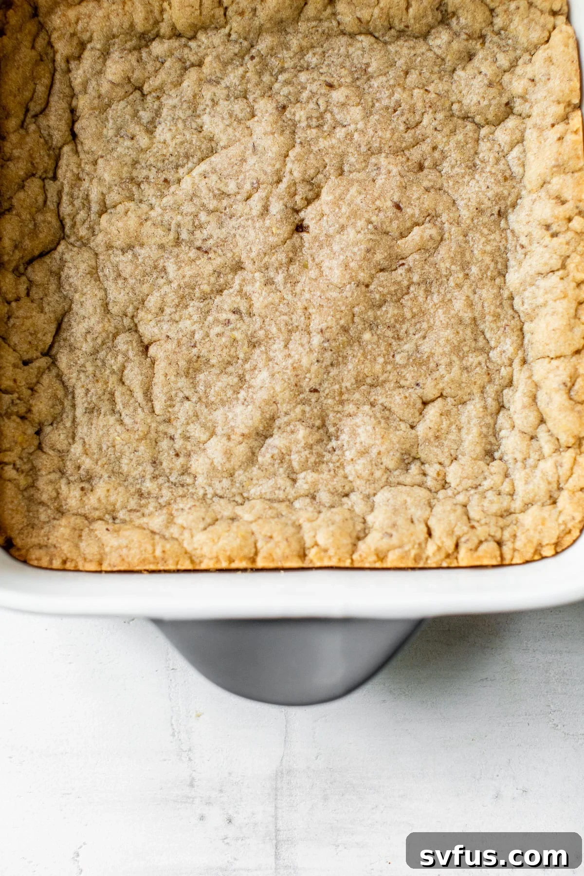 Freshly baked blondies in an 8x8 baking dish, golden brown and perfectly set.