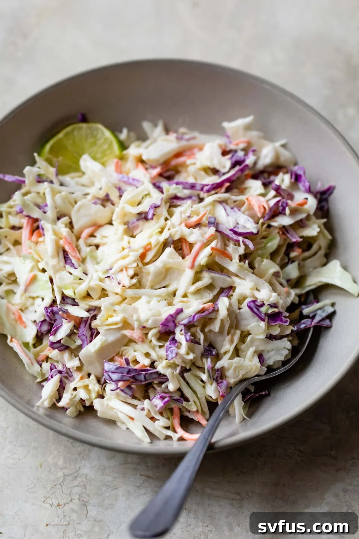 homemade coleslaw in a bowl with a fork, ready to be served