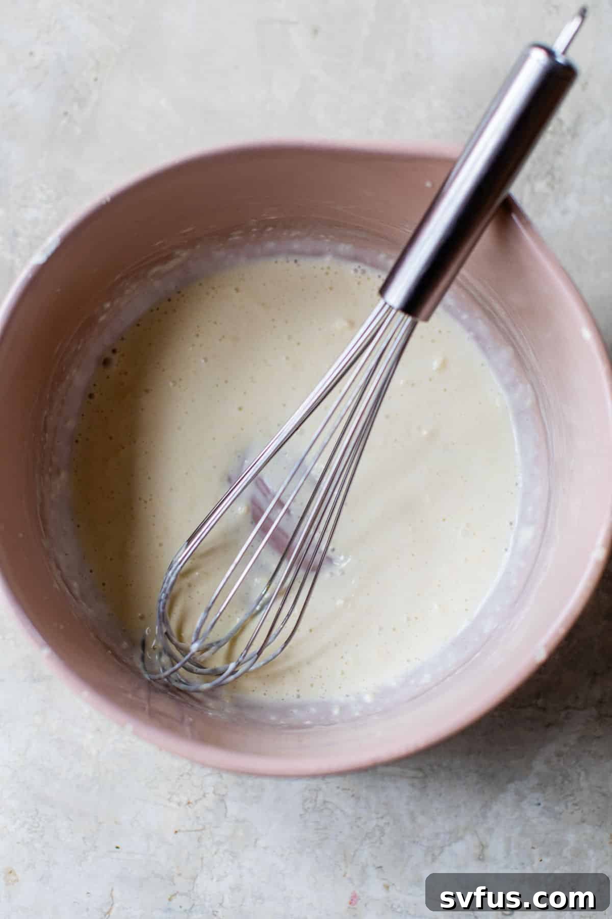 mayo, apple cider vinegar, lime juice, and sugar whisked together in a bowl, forming a creamy dressing