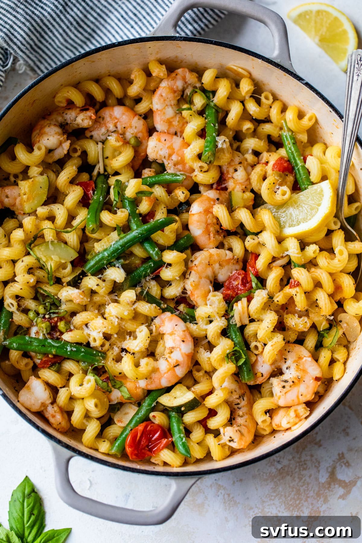 shrimp primavera in a dutch oven with a spoon