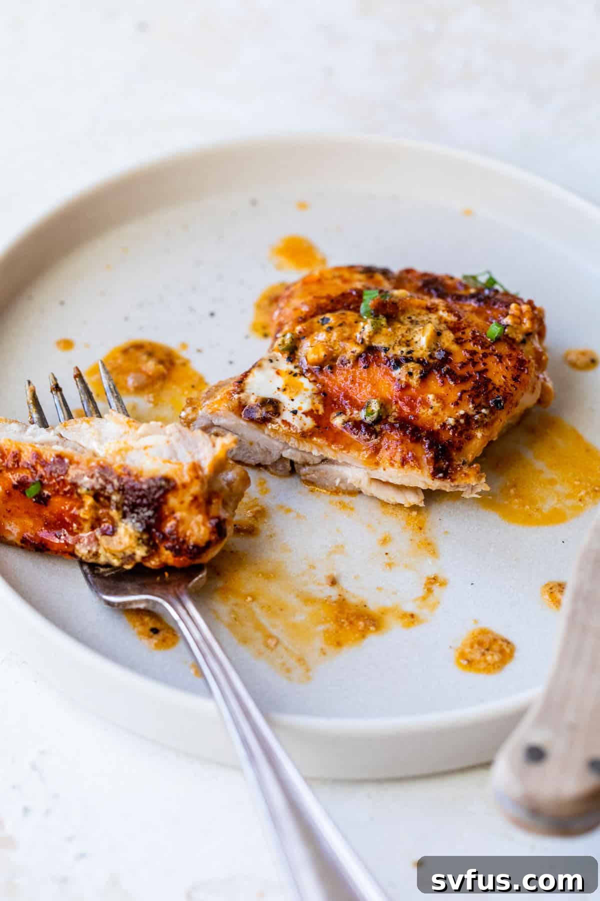 Golden-brown paprika chicken served on a white plate, garnished with fresh herbs, ready to be enjoyed.