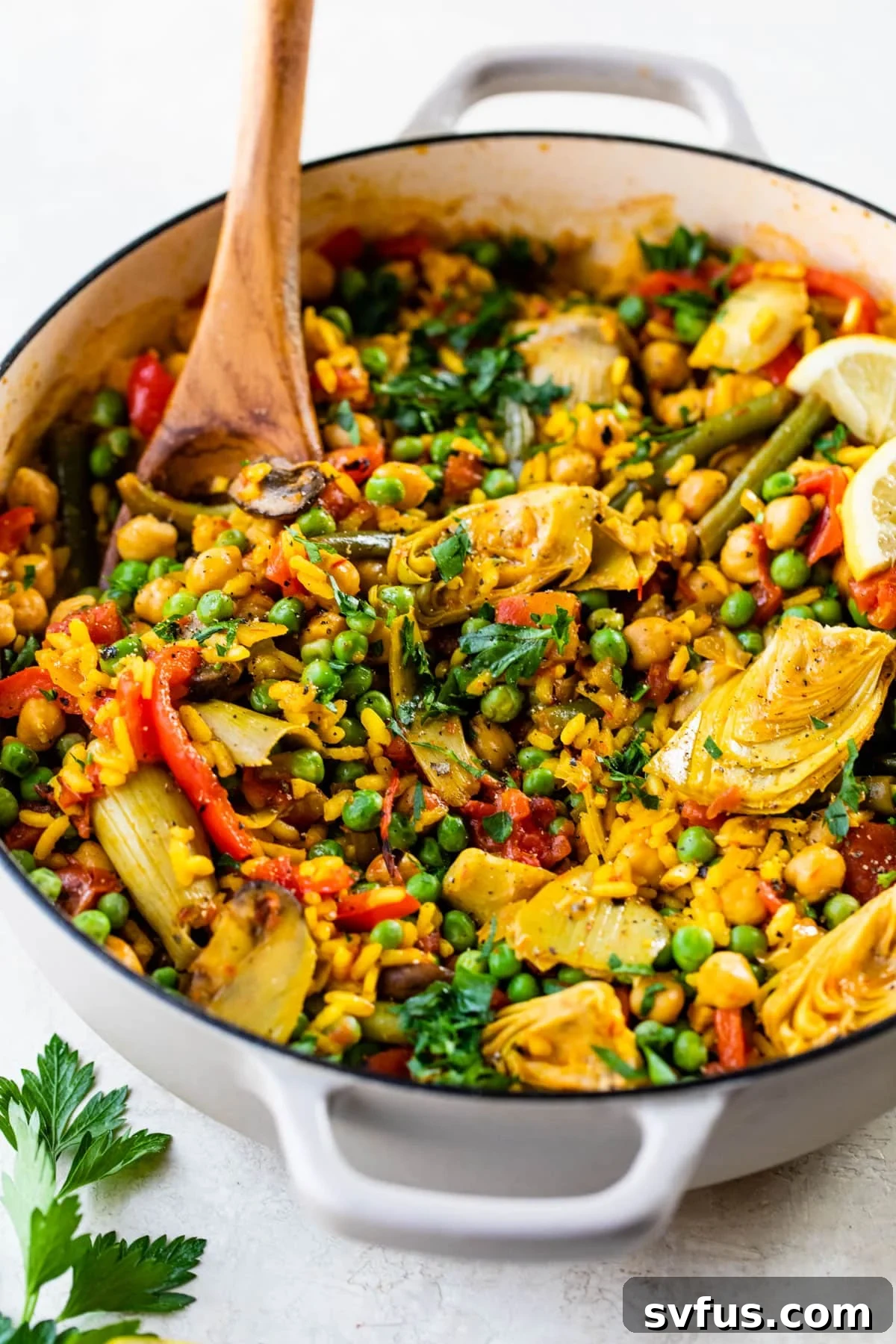 vegetable paella in a dutch oven with a wooden spoon